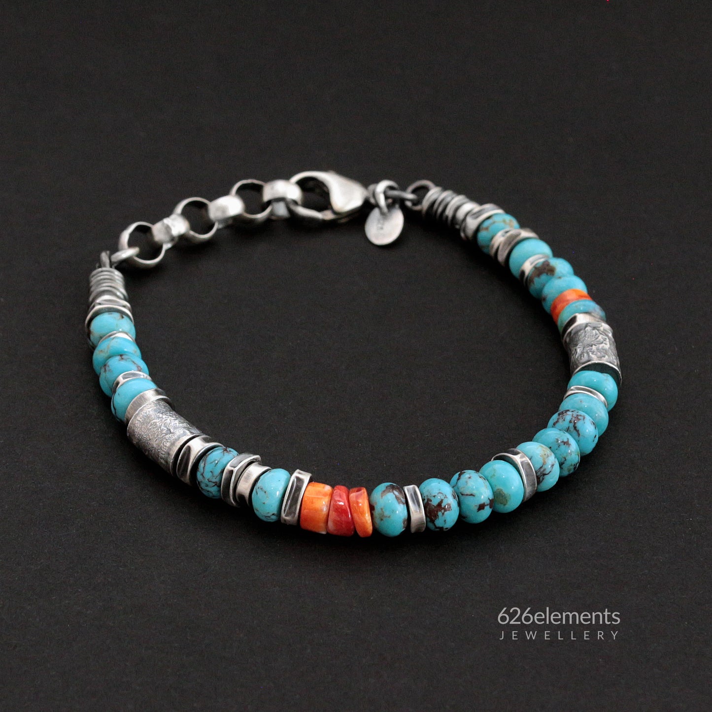 Oxidised sterling silver bracelet with blue turquoise and orange spiny oyster beads on a dark background